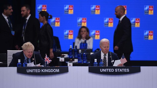 Le président américain Joe Biden (droite) et le premier ministre britannique Boris Johnson (gauche) à la table ronde des chefs d'État du Conseil de l'Atlantique Nord pendant le sommet de l'OTAN, le 30 juin 2022 à Madrid en Espagne.