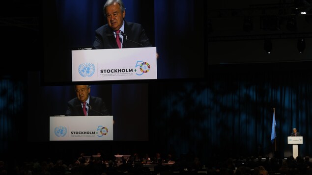 Antonio Guterres, le secrétaire général des Nations Unies debout dans une tribune au Sommet de la terre à Stockholm.