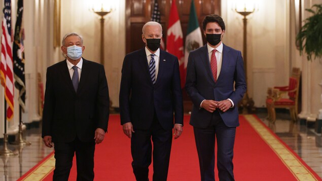 Le président Joe Biden, le premier ministre canadien, Justin Trudeau, et le président mexicain, Andres Manuel Lopez Obrador, traversent ensemble le Cross Hall de la Maison-Blanche à Washington.