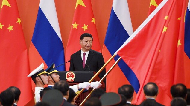 M. Xi devant des drapeaux.