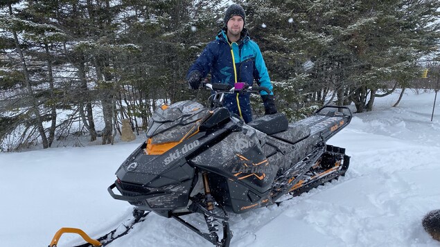 Donat Lebrasseur avec sa motoneige dans le bois