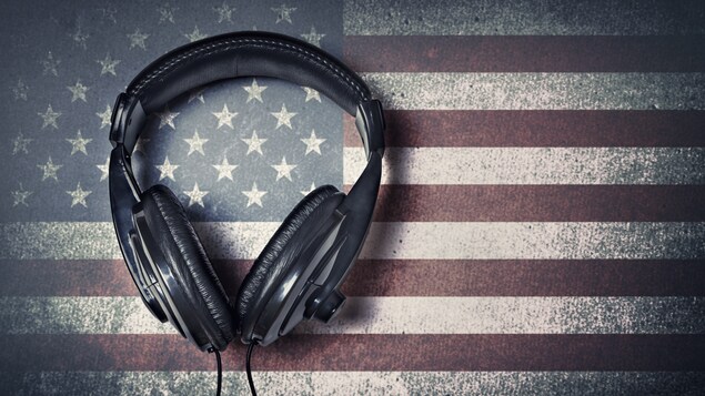 Une paire d'écouteurs, au-dessus d'une infographie d'un drapeau américain