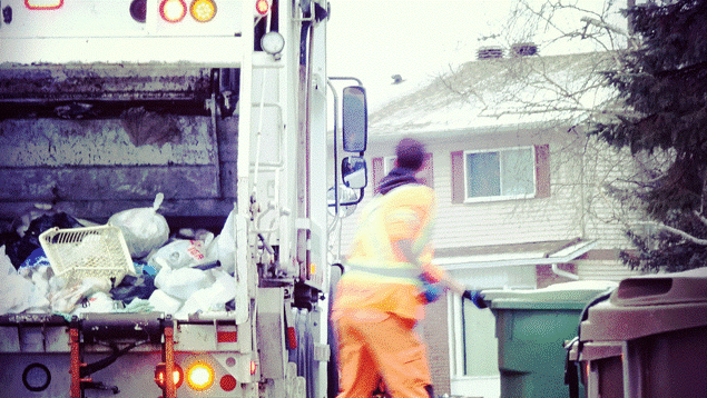 Un homme vêtu d'orange met des déchets dans un camion. Un homme vêtu d'orange met des déchets dans un camion.