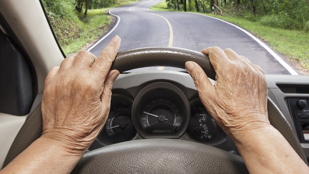 Un aîné conduisant sur une route de campagne.