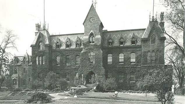 Photo en noir et blanc montrant une grande école.