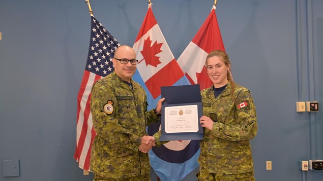 Élizabeth Audet reçoit son certificat de réussite militaire des mains du colonel Richard Jolette.