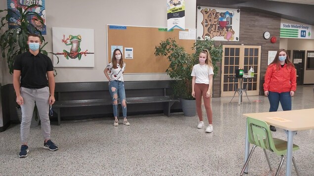 Quatre étudiants du Cégep de Baie-Comeau, à 2 mètres de distance, portant un masque.