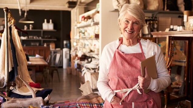 Une femme aînée qui travaille dans un commerce.