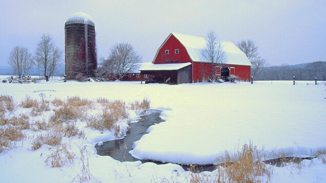Une ferme dans un paysage hivernal.