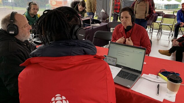 Plusieurs personnes assises autour d'une table prennent part 
à une entrevue radio