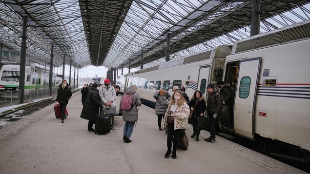 Des gens descendent d'un train à la gare Centrale d'Helsinki, en Finlande, le 3 mars 2022. 