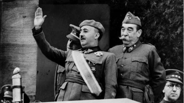Le général Franco salue la foule dans son habit militaire.