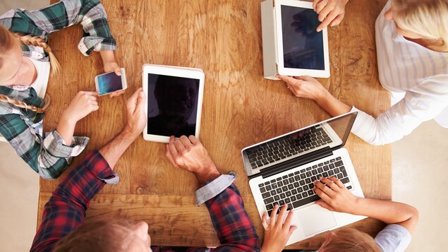 Une famille utilise divers outils électroniques.