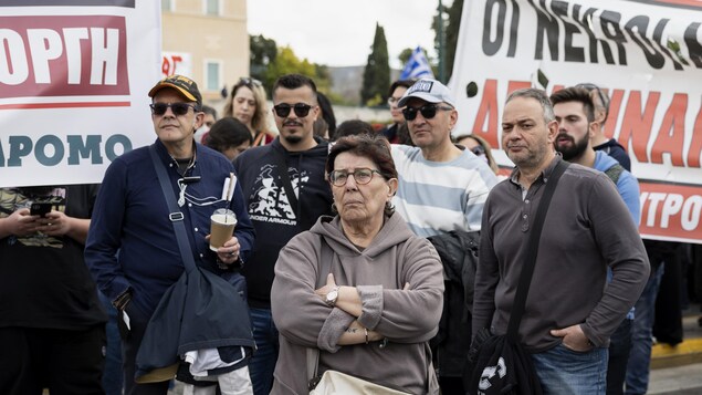 Un groupe de manifestants agacés écoutent un discours.