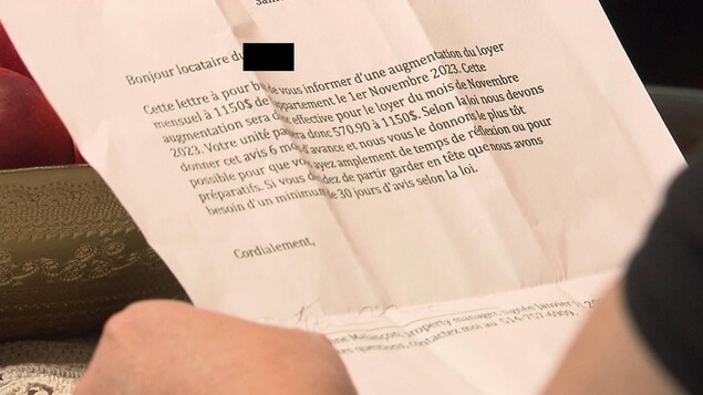 Une personne tient une lettre fripée de son propriétaire.