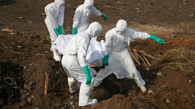 Des travailleurs humanitaires transportant les corps des victimes de l'Ebola lors de la dernière crise majeure en 2014 au Sierra Leone.