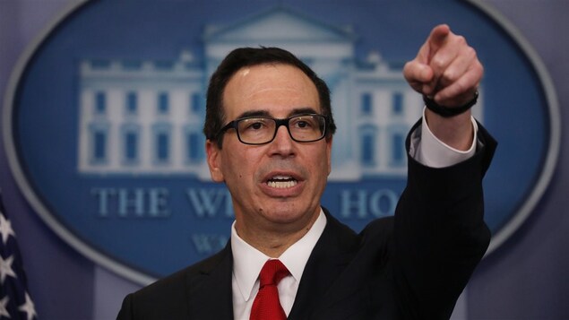 Steve Mnuchin, au cours d'un point de presse, montrant du doigt quelqu'un ou quelque chose.