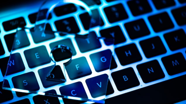 Un gros plan du clavier d'un ordinateur avec un cadenas transparent déposé dessus.