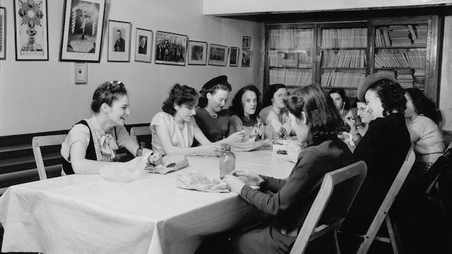 Des membres du Cercle des fermières de L'Ancienne-Lorette sont assises autour d'une table.