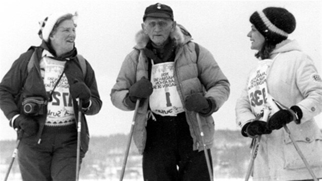 Le  skieur Herman « Jackrabbit » Smith-Johannsen est entouré de deux skieuses.