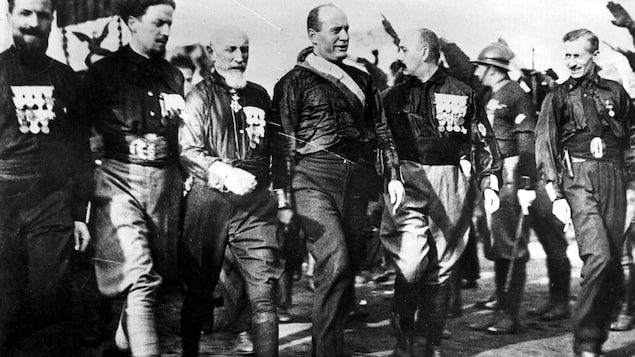 Benito Mussolini, au centre, et ses partisans marchent.