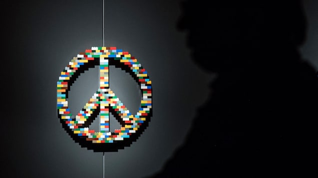Une sculpture représentant le symbole de la paix en blocs Lego.