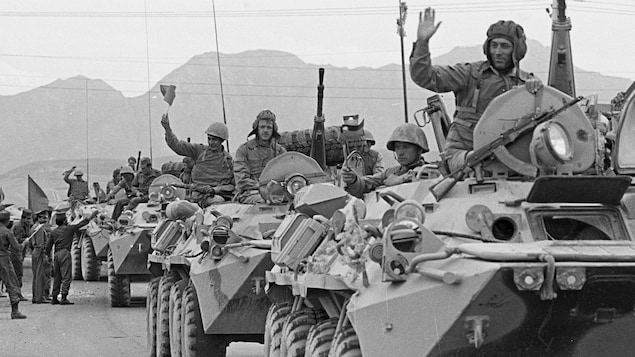 Des soldats soviétiques à bord de tanks saluent la foule à Kaboul, le 15 mai 1988.