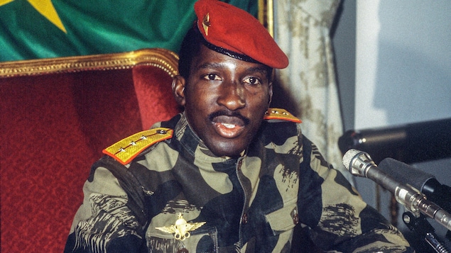 Assis, Thomas Sankara parle devant des micros.
