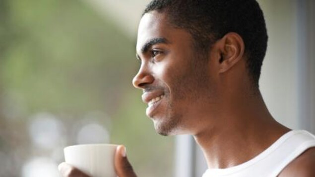 Un homme boit un café le matin.