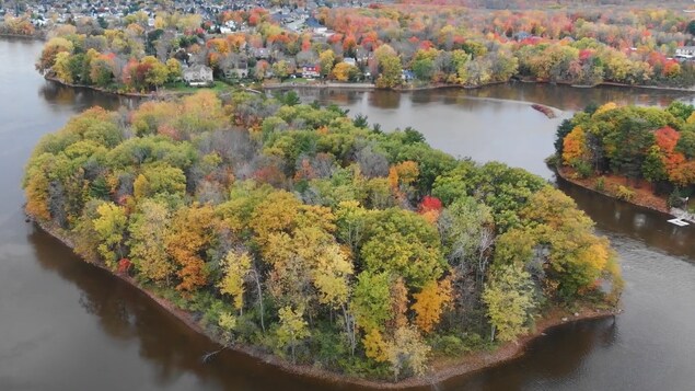 Vue aérienne de l'île de 3 hectares sur la rivière, un jour d'automne. 