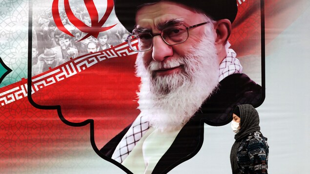 Une Iranienne passe devant une peinture murale montrant le guide suprême de l'Iran, l'ayatollah Ali Khamenei, dans la capitale Téhéran.