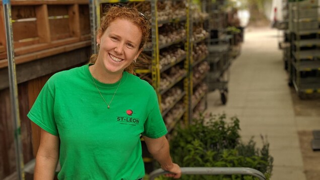 Janelle Rémillard tire un chariot ayant les pots de plantes.