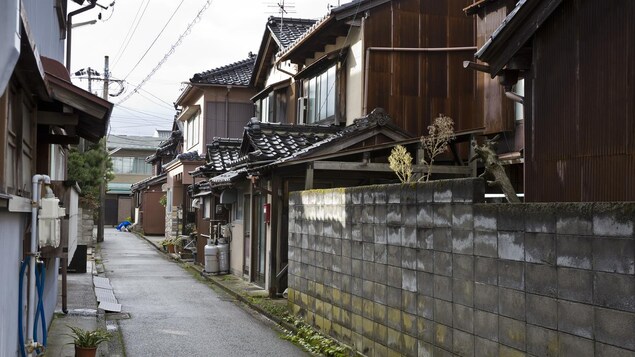 Enchaînement de vieilles maisons japonaises dans une rue étroite.
