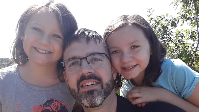 Yvon Brais prend un autoportrait entouré de ses deux filles
