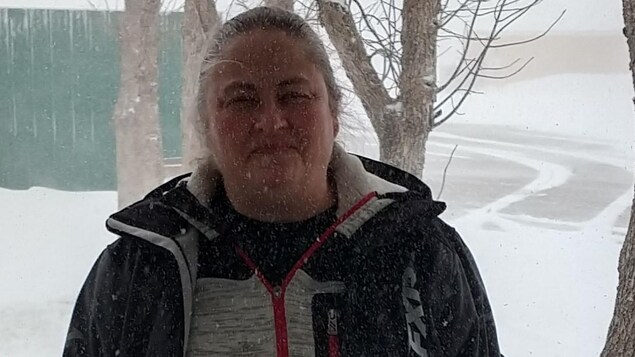 Une femme dehors dans une tempête de neige.
