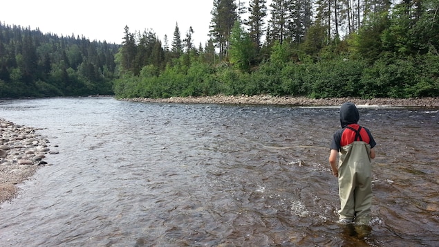 Jeune pêchant sur la rivière Godbout Jeune pêchant sur la rivière Godbout