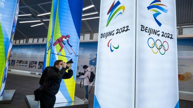 Un journaliste prend des photos au centre d'exposition des Jeux olympiques d'hiver de Pékin.