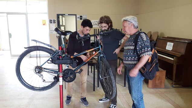 Des cyclistes réparent un vélo dans un atelier de la Coopérative La Déraille de l'Université de Sherbrooke