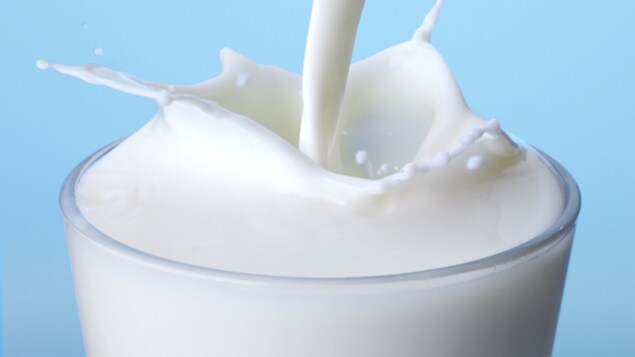 Du lait est versé dans un verre et il fait des éclaboussures. Le bon vieux lait ordinaire est tout aussi bon que le lait à valeur ajoutée.