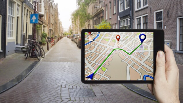 Une tablette affichant une application GPS dans un décor urbain.