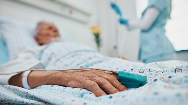 Une personne âgée couchée dans un lit d'hôpital.