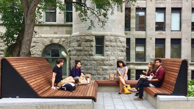 Des jeunes sur les bancs en bois.