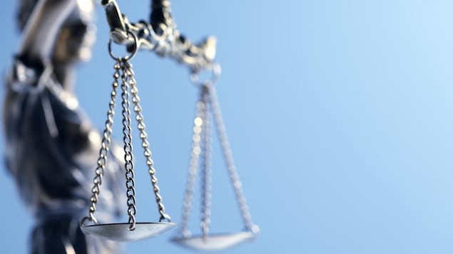 Gros plan sur la balance que porte la statue de la Justice.