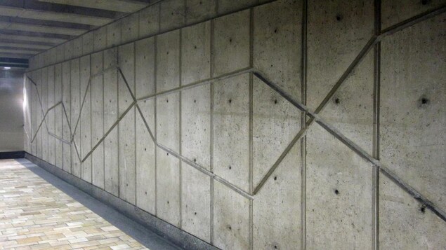 Un mur en béton sur le quai d'une station de métro.