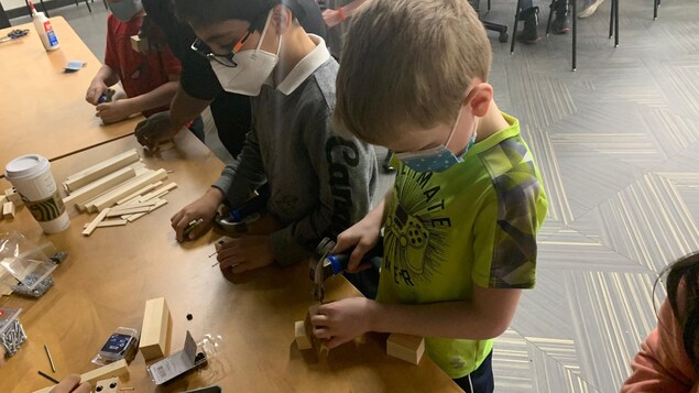 Des enfants font du travail du bois. 