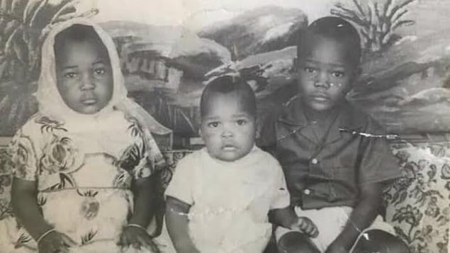 Trois jeunes enfants sur une photo d'époque.