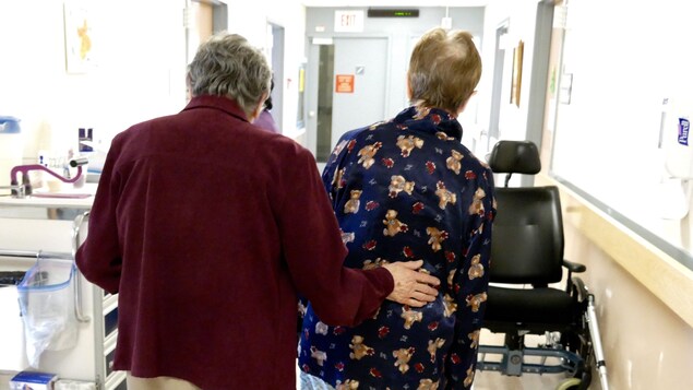 Deux femmes âgées marchent dans un corridor d'un centre.