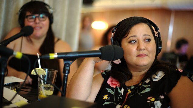 Julie Artacho, à gauche, et Manal Drissi, qui regardent vers leur gauche avec des écouteurs sur la tête.