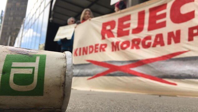 Des Vancouvérois portant une bannière sur laquelle on peut lire: « Rejetez le pipeline de Kinder Morgan » devant la Banque TD au centre-ville, le 10 mars 2017