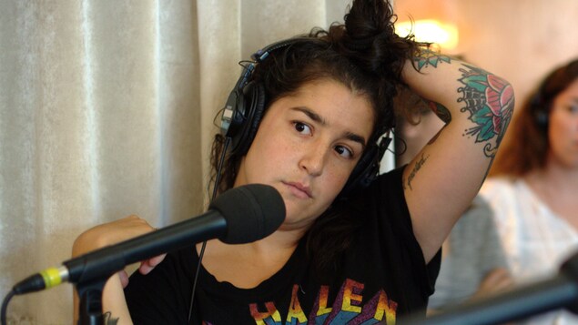 Mariana Mazza passe sa main gauche dans ses cheveux.